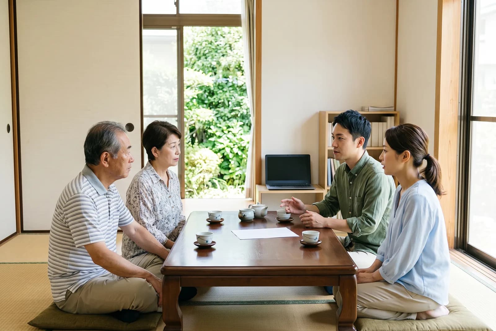 居間のテーブルを挟んで、家族が話し合っている様子