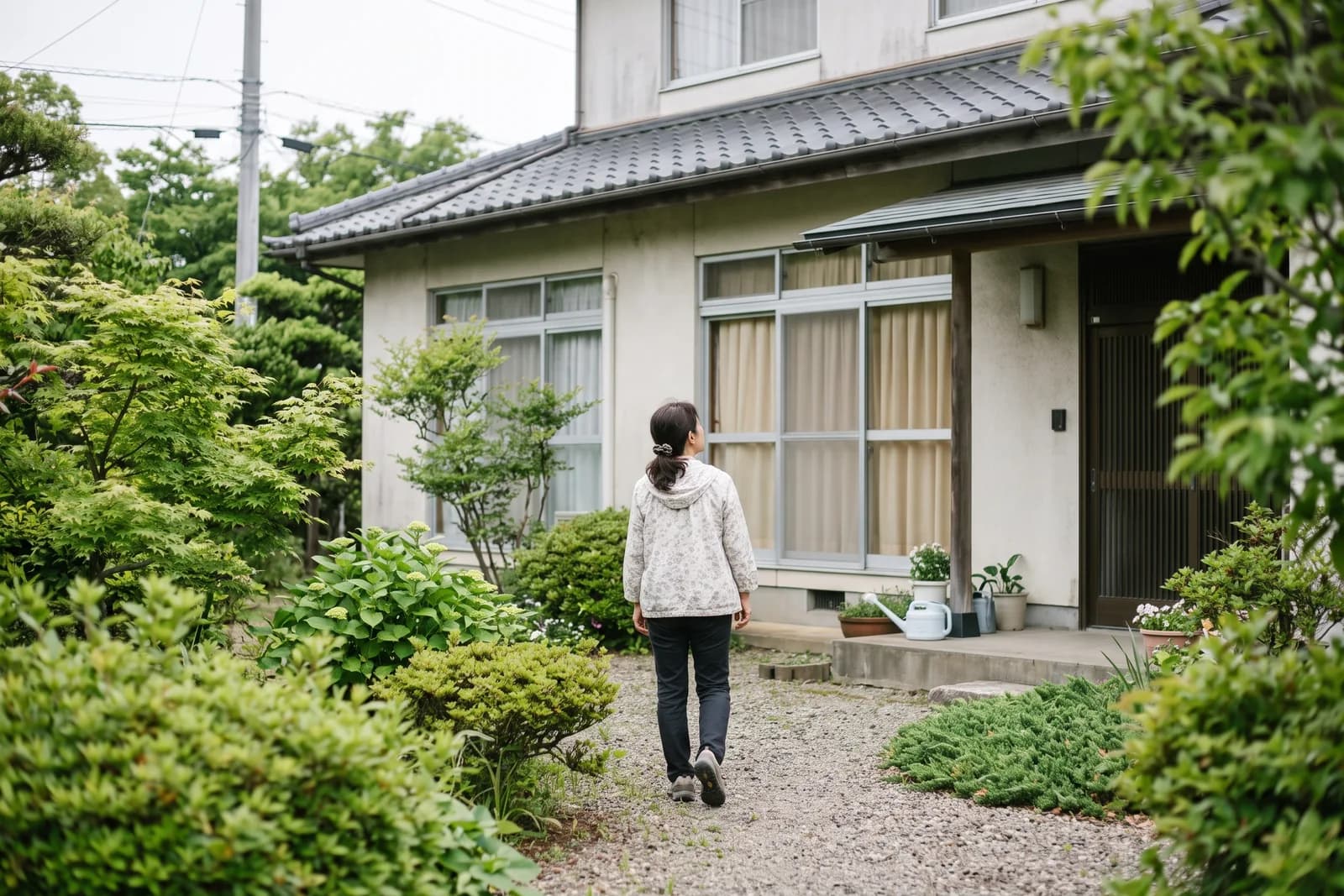 庭先で、家の外観を眺めながら歩いている後ろ姿